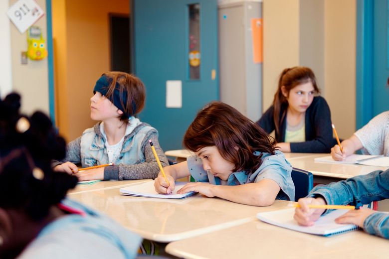 Eine Primarschülerin schreibt konzentriert in ihr Heft.